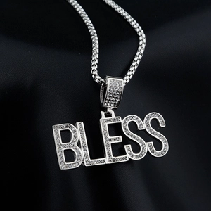 Macro detail of silver BLESS letter pendant with sparkling white diamonds on black leather