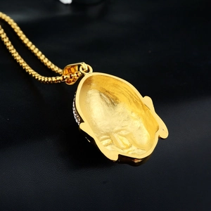 Colgante de cabeza de Buda dorado hip hop con diamantes sobre fondo de cuero negro