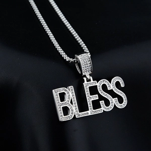 Macro shot of the BLESS letter pendant featuring iced-out silver metal and pavé crystals