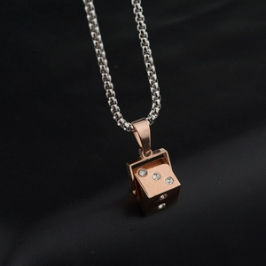 Trendy rose gold dice pendant necklace with sparkling crystal inlay on black background