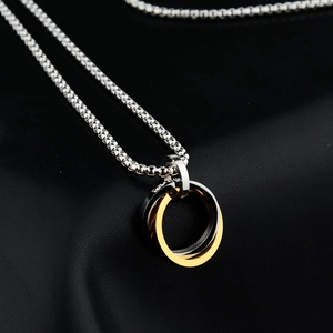 Collana moderna con pendente a due anelli intrecciati in oro e argento su sfondo in pelle