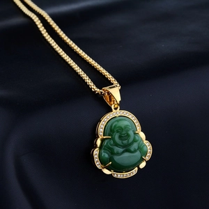 Green Buddha pendant necklace in gold setting with diamonds on blue satin background