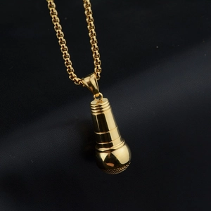 Hip hop gold microphone pendant necklace with chunky box chain on black leather background