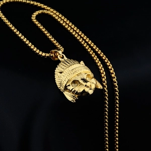 Detailed close-up of golden Elvis cat pendant with Indian feather headpiece and bead chain