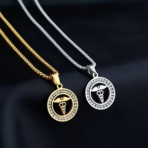 Dettaglio di collane caduceo medico in oro e argento con cristalli su pelle nera