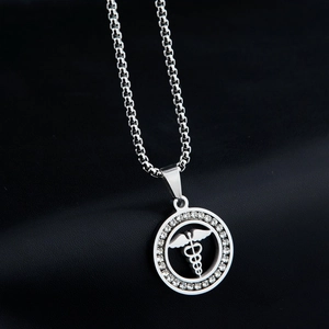 Dettaglio di una collana in acciaio al titanio argento con pendente Caduceo e piccoli cristalli