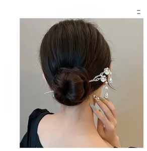 Silver hairpin with lily of the valley and pearls styled in a traditional bun hairstyle