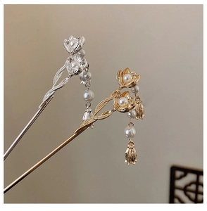Detailed close-up of a vintage lotus hair pin with pearls and tassels in gold and silver
