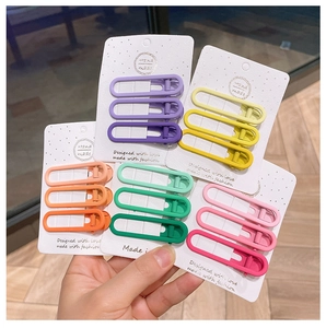 Close-up of matte alloy hair clips in various gradient colors on handmade cardboards