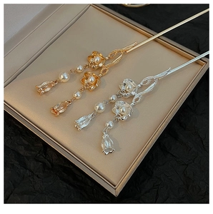 Detail of vintage lotus hairpins with pearls and tassels in gold and silver finish