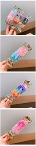 Detailed view of colorful elastic hair bands in candy shaped packaging for girls