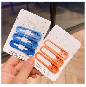 Close-up of matte gradient hair clips in blue and orange on handmade card display