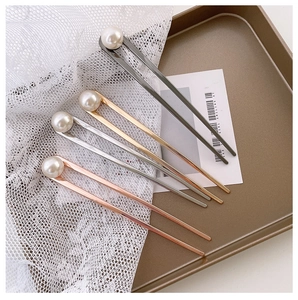 Détail d'épingles à cheveux minimalistes en forme de U en or et argent avec perles