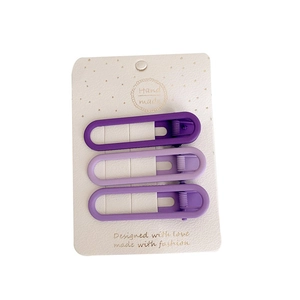 Three gradient purple alloy hair clips in matte finish on white display card