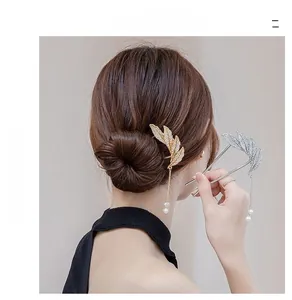 Detail of leaf hair pin with rhinestones and pearl tassels on an elegant bun