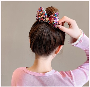 Close-up of a colorful sequined bow hair clip worn on a girl's hairstyle