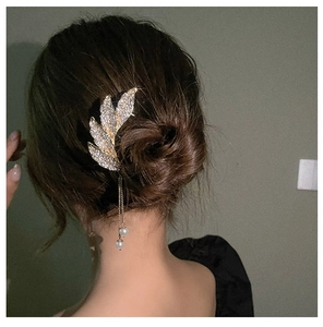 Detail of leaf hair pin with sparkling rhinestones and elegant hanging pearl tassels