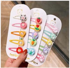 Close-up of 15-piece colorful cartoon fruit and floral hair clips for girls on display cards