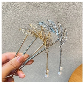 Detail of leaf-shaped hairpin with sparkling rhinestones and elegant pearl tassels