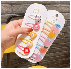 Detail of colorful cartoon hair clips featuring fruit patterns for children and girls