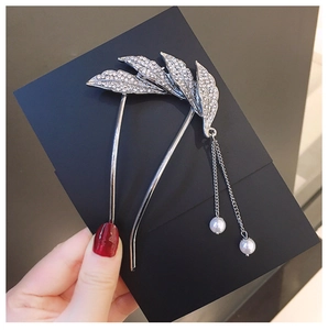 Close-up of silver U-shaped hair pin featuring leaf rhinestones and pearl tassels
