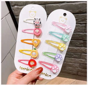 Close-up of cute cartoon hair clips featuring colorful fruit, animals, and cat paw designs