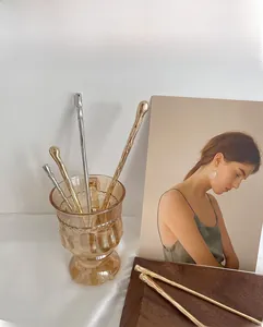 Close-up of gold and silver minimalist metal hairpins with unique wavy texture finish