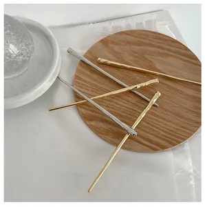 Close-up of gold and silver hair pins with handcrafted hammered texture and sleek design