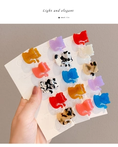 Primer plano de pinzas para el cabello con forma de gato en acetato de colores para niños