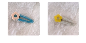 Close-up of floral acetate duckbill hair clips in pastel blue and translucent white