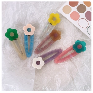 Set of 6 colorful acetate hair clips with matte flower details on textured background