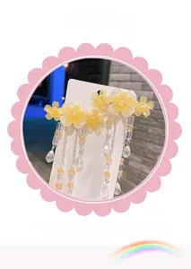 Détail de barrettes à fleurs jaunes avec centre en perle et élégantes pampilles perlées