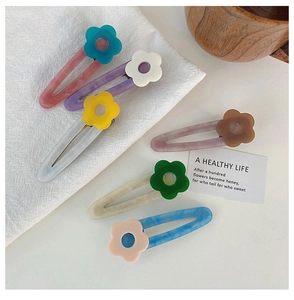 Close-up of acetic acid hair clips with marble texture and cute floral patterns