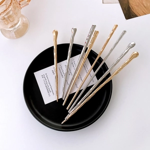 Minimalist metal hair sticks set in gold and silver with irregular ripple texture