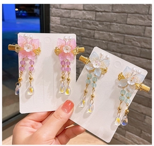 Détail de pinces à cheveux florales faites main avec de longs glands pour filles