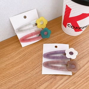 Set of 4 acetate floral hair clips with terrazzo texture on a wooden background