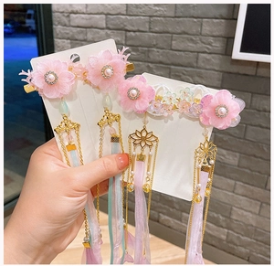 Détail de la pince à cheveux Hanfu avec fleur en dentelle rose, gland doré et rubans en soie