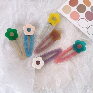 Set of six colorful acetate flower hair clips with marble texture on white paper background