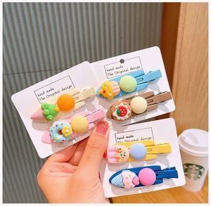 Detailed view of colorful dessert resin hair clips including cupcake and ice cream designs