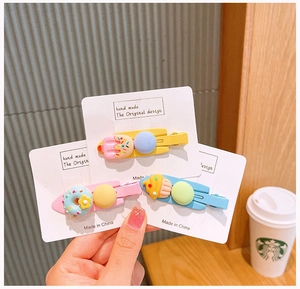 Detailed view of three candy-colored dessert hair clips including cupcake and ice cream shapes