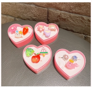 Close-up of children's cartoon rings featuring cute fruit and animal resin patterns
