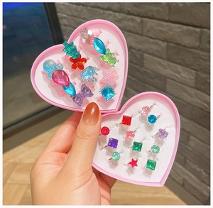 Close-up of colorful cartoon gemstone rings for girls in a pink heart-shaped gift box