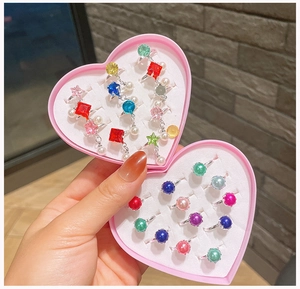 Close-up of kids adjustable colorful gemstone rings set in pink heart shaped boxes