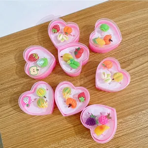 Detail of colorful fruit and vegetable resin rings set in pink heart-shaped gift boxes