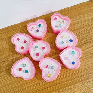 Flat lay of colorful gemstone rings for girls in heart boxes on a wooden table