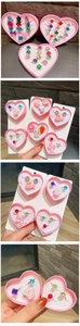Detail of children's toy ring set with cute animal and fruit shapes in pink heart box