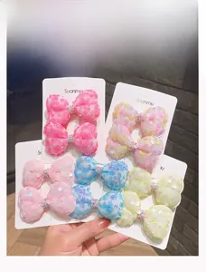 Dettaglio di fermagli per capelli a fiocco glitterati in rete con strass multicolore