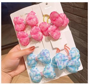 Dettaglio di fiocchi per capelli con paillettes rosa e blu e strass su cartoncino