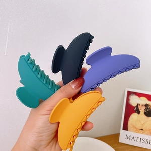 Set of four matte geometric hair claws in teal, blue, purple, and orange colors