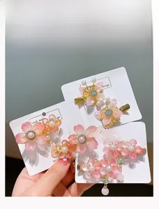 Detailweergave van handgemaakte roze kersenbloesem haarspelden met parels en steentjes